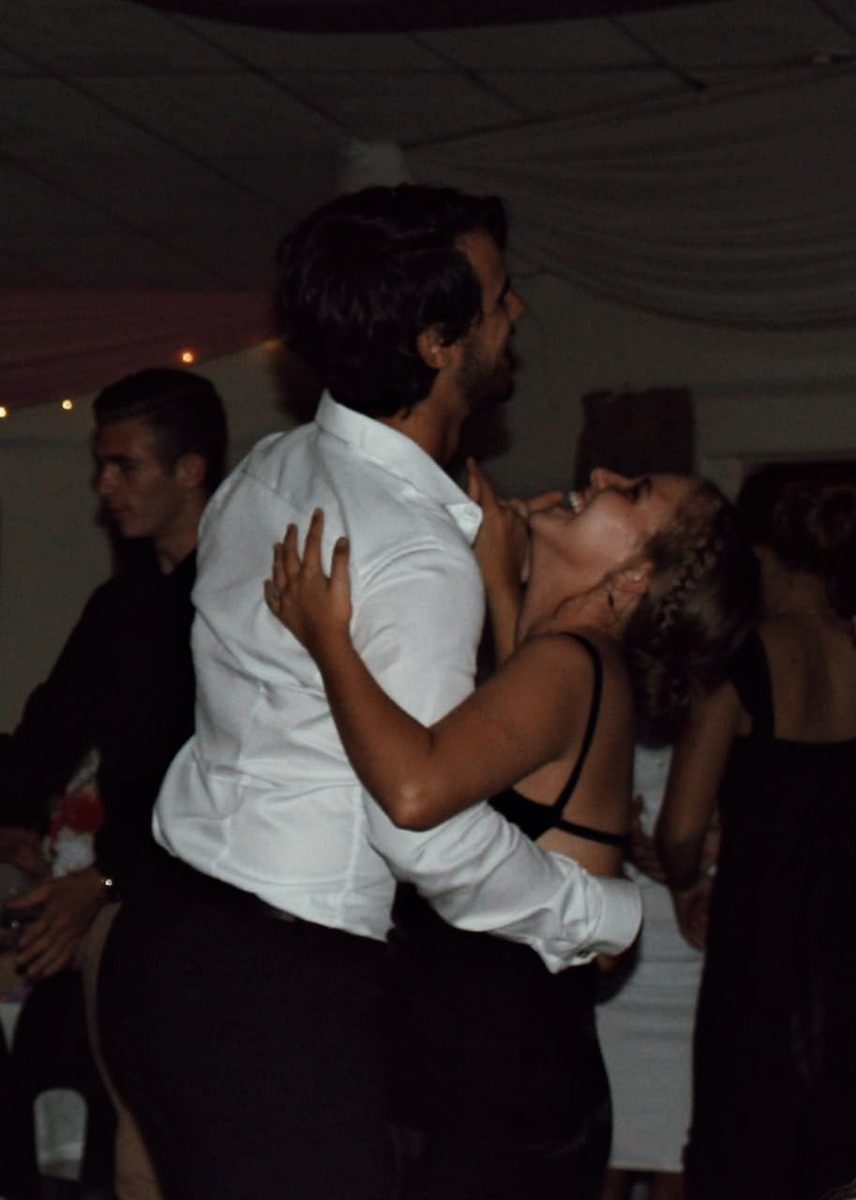 Ian and Chavón close together on a dimly lit dance floor.